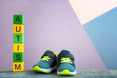 Photo of Training shoes and cubes with word "Autism" on table