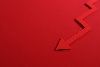 One zigzag paper arrow on red background, closeup. Space for text
