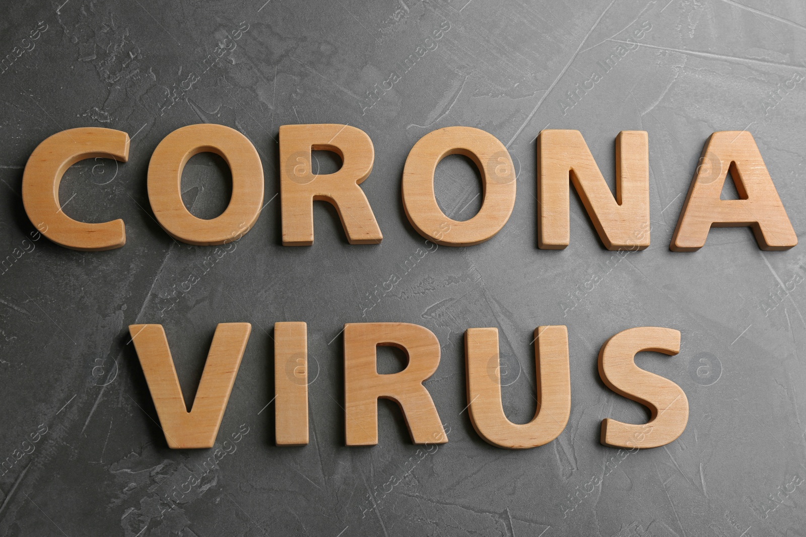 Photo of Words CORONA VIRUS made of wooden letters on grey table, top view