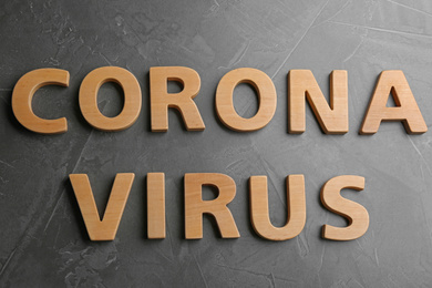 Photo of Words CORONA VIRUS made of wooden letters on grey table, top view