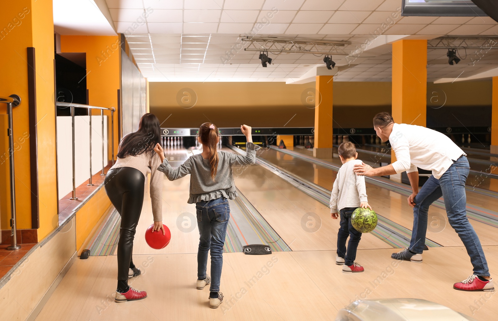 Photo of Happy family spending time together in bowling club