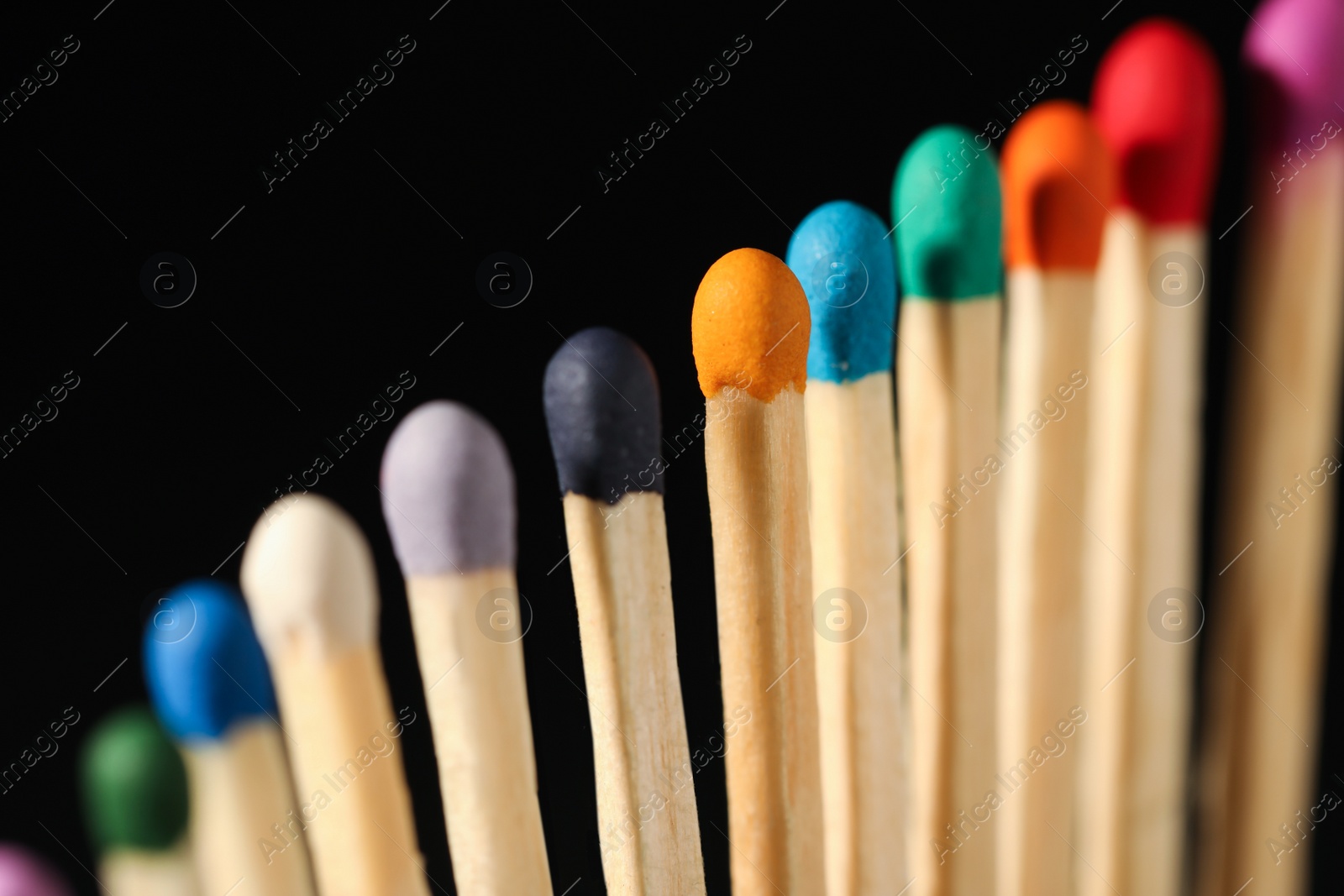 Photo of Matches with colorful heads on black background, closeup