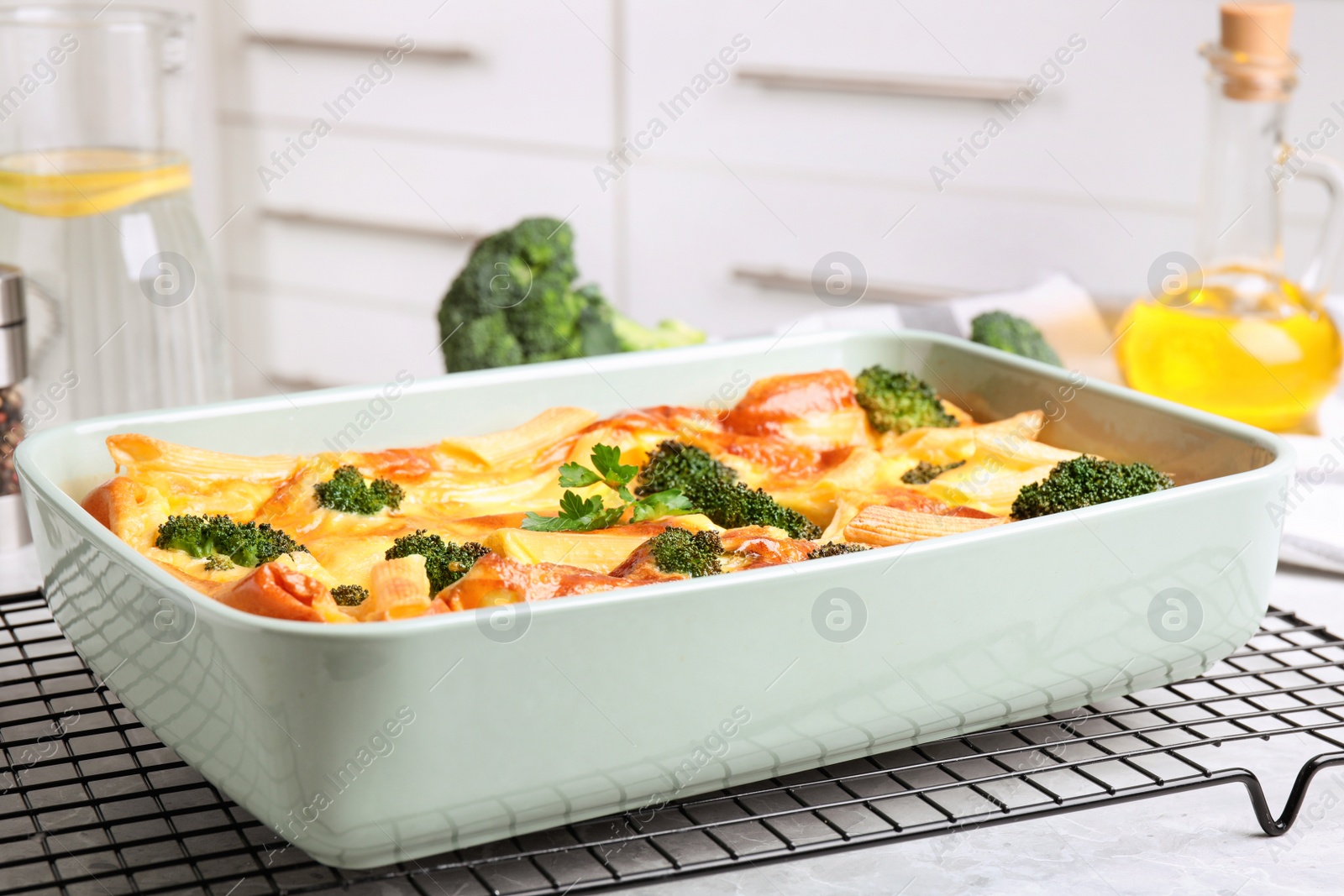 Photo of Tasty broccoli casserole in baking dish on cooling rack indoors