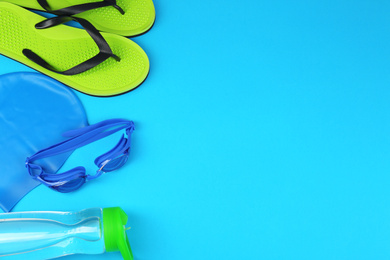 Photo of Flat lay composition with swimming accessories on light blue background. Space for text