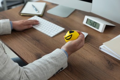 Photo of Man with antistress ball at desk in office, closeup