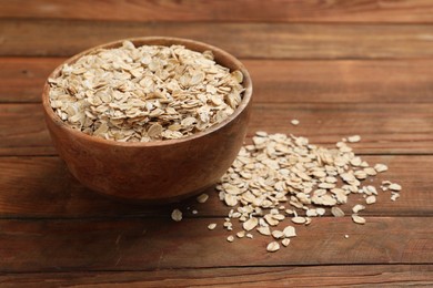 Photo of Bowl with oatmeal on wooden table, closeup