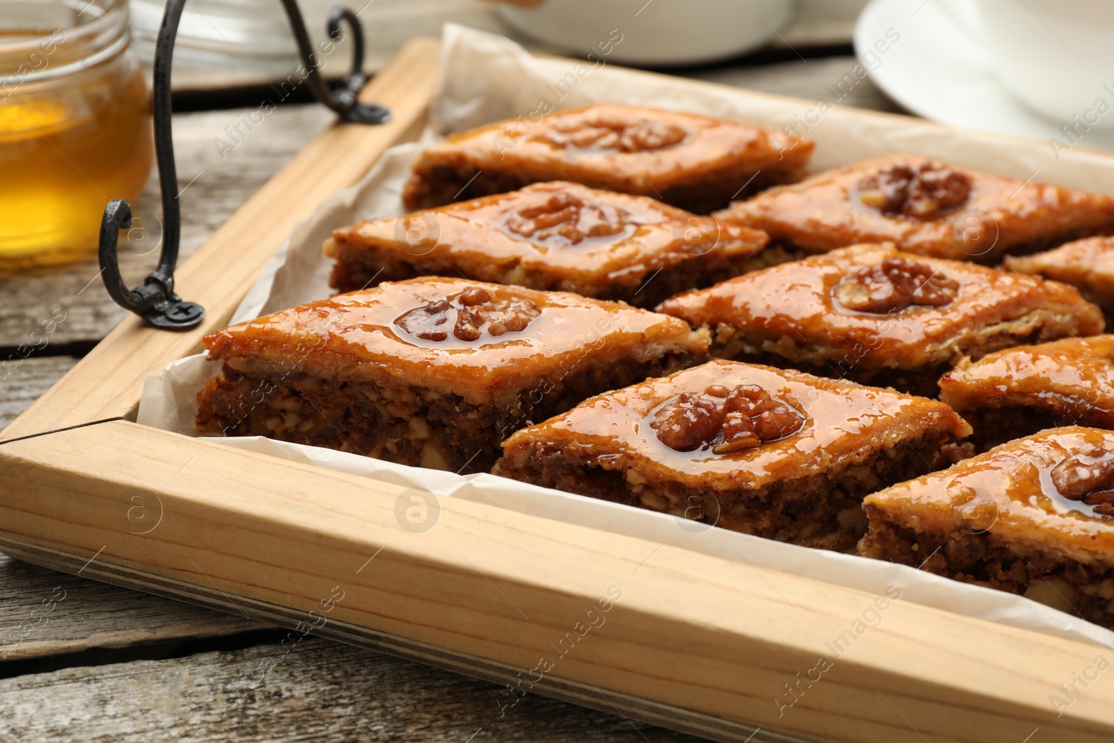 Photo of Delicious sweet baklava with walnuts on wooden table, closeup