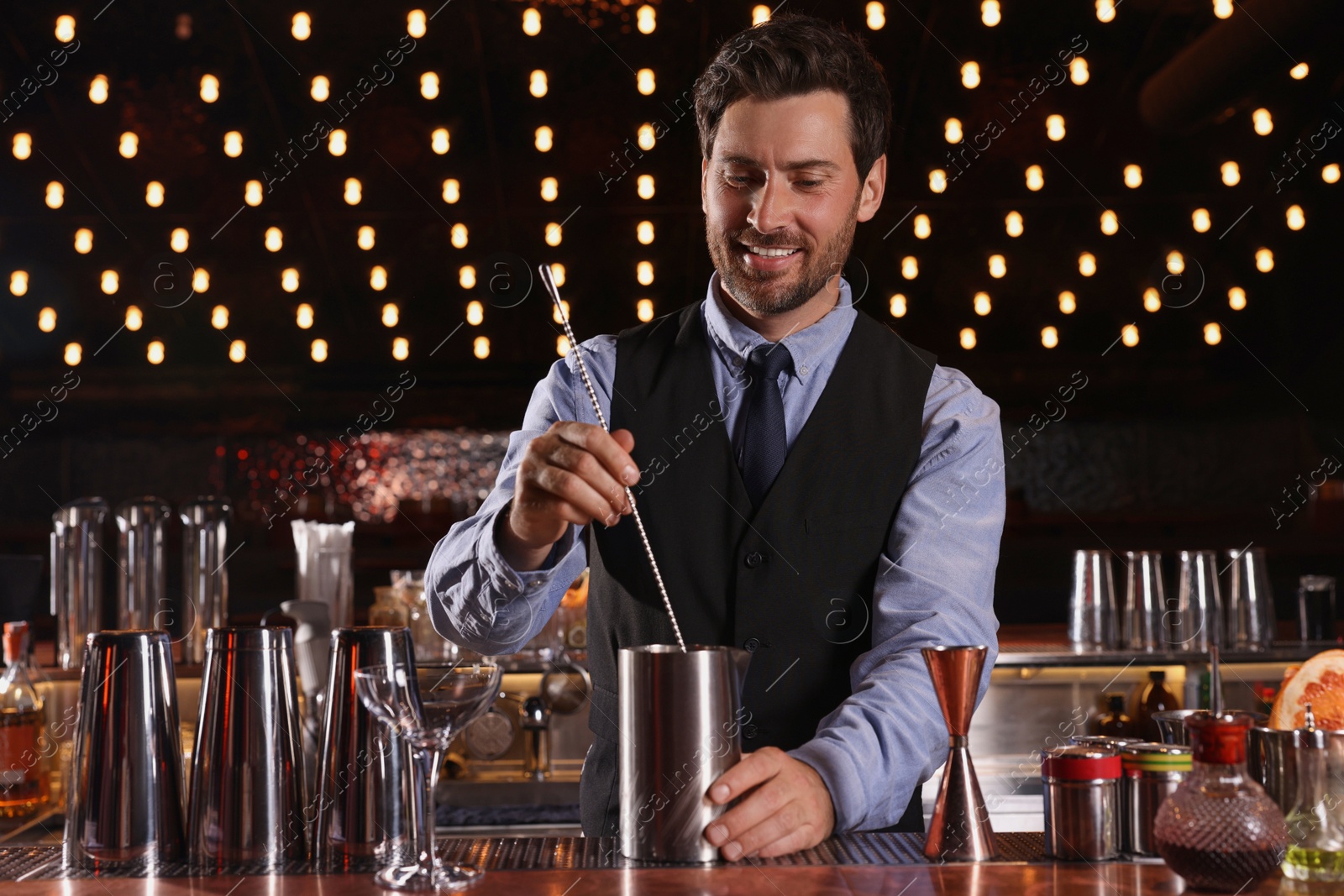 Photo of Bartender preparing fresh alcoholic cocktail in bar