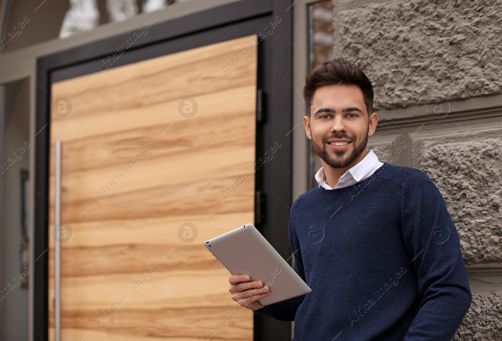 Photo of Young male business owner with tablet near his cafe. Space for text