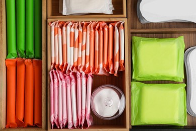 Photo of Storage of different feminine hygiene products in wooden organizers, top view