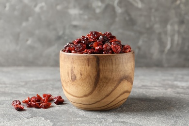 Photo of Bowl with sweet cranberries on table. Dried fruit as healthy snack