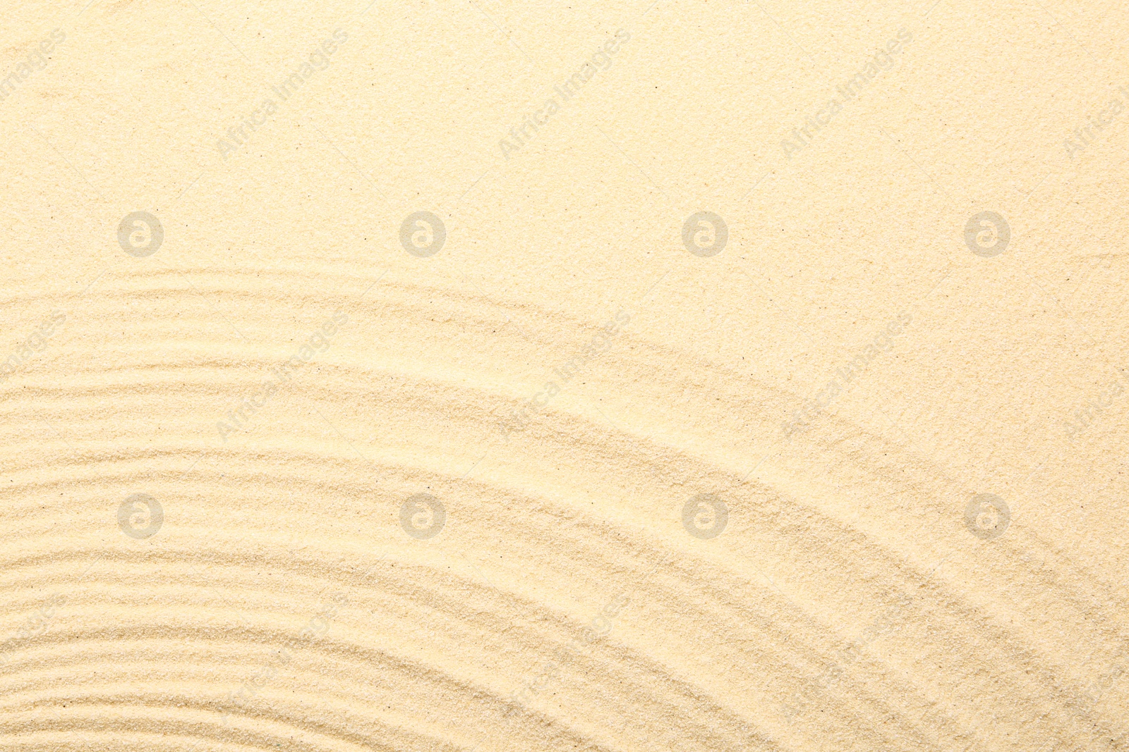 Photo of Zen rock garden. Wave pattern on beige sand, top view