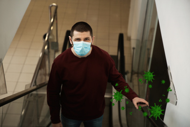 Man wearing medical mask on escalator in mall. Dangerous virus