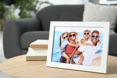 Frame with family photo and books on coffee table indoors