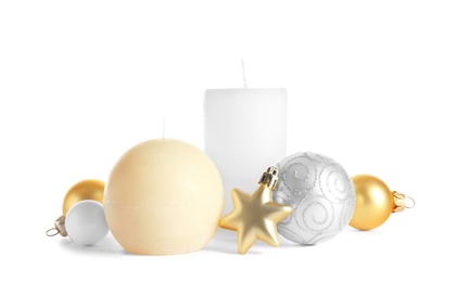 Different wax candles and Christmas decorations on white background