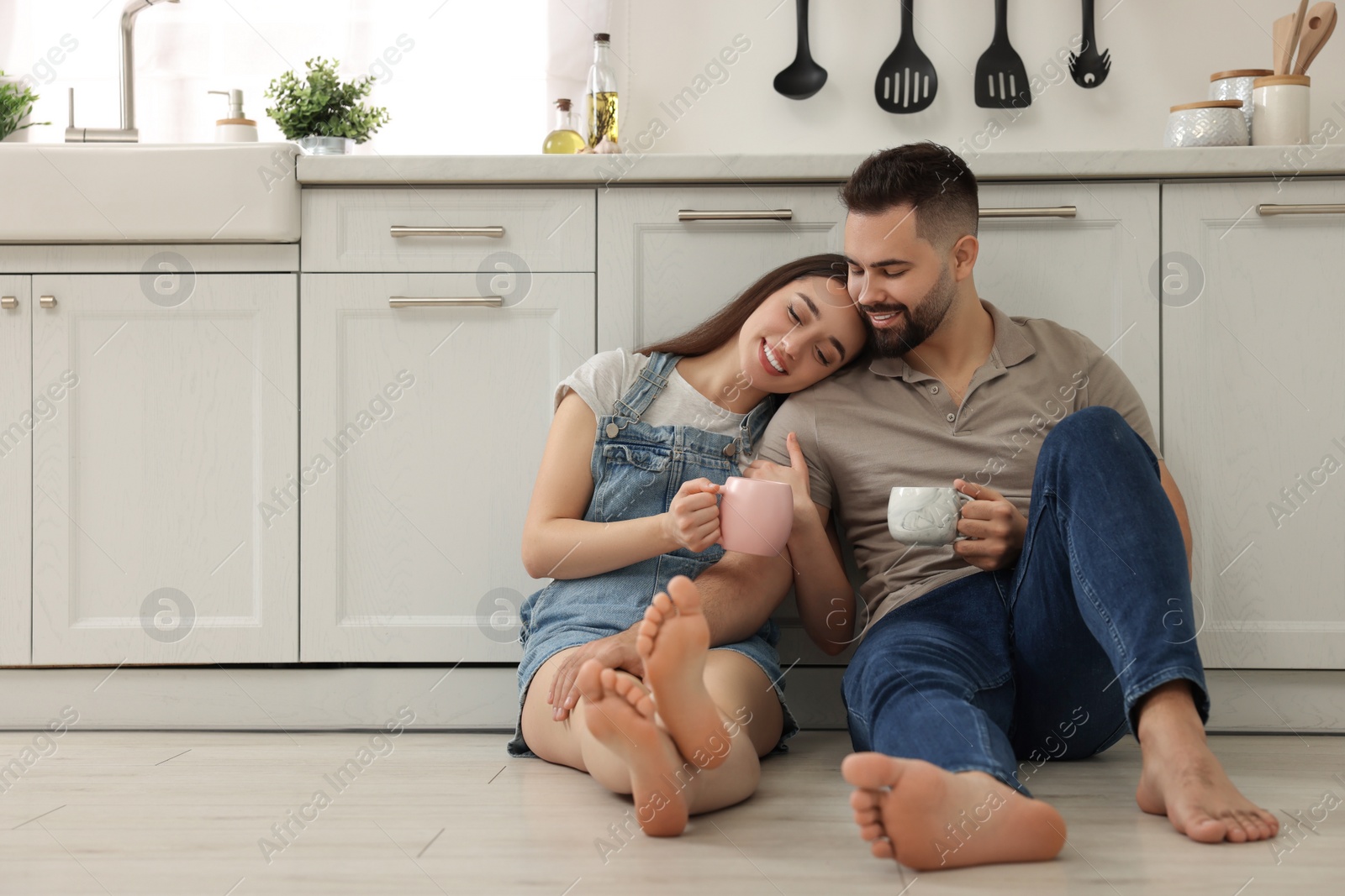 Photo of Affectionate young couple spending time together in kitchen. Space for text