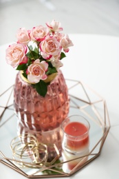 Photo of Vase with beautiful flowers and candle on white table indoors, closeup. Interior elements