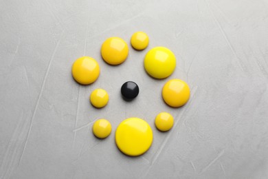 Black and yellow magnets on light grey background, flat lay. Racism concept