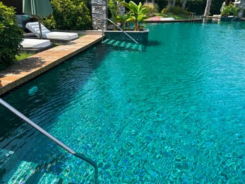 Photo of Metal rail and steps in outdoor swimming pool