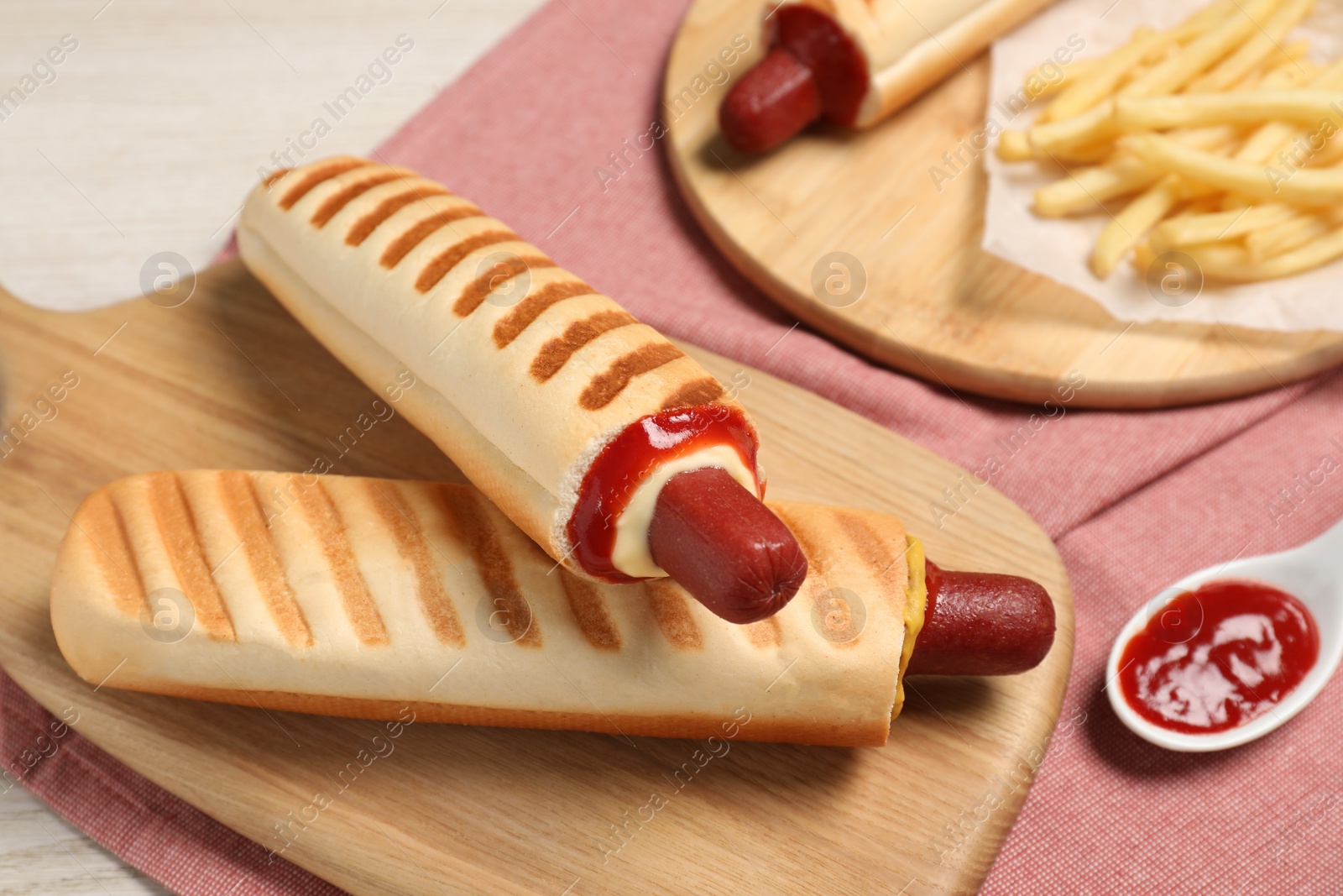 Photo of Delicious french hot dogs, fries and dip sauce on table, closeup