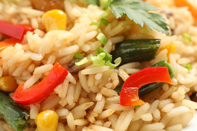 Photo of Delicious rice pilaf with vegetables as background, closeup