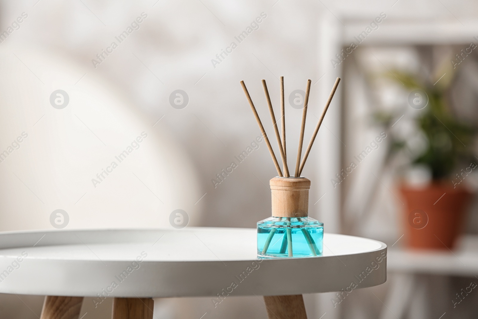 Photo of Reed air freshener on white table indoors, space for text