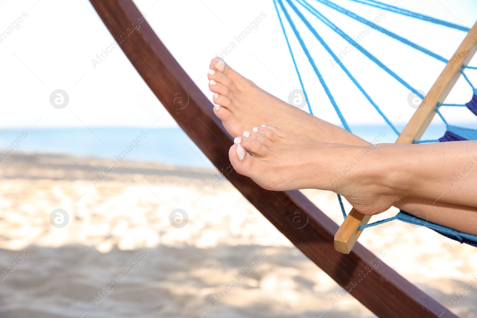 Photo of Young woman relaxing in comfortable hammock at seaside