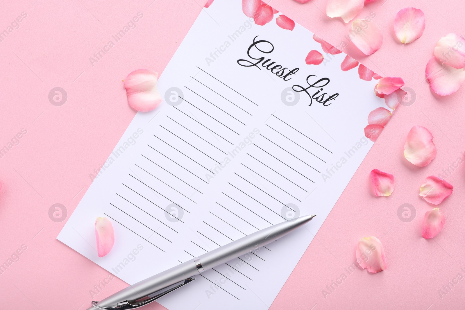 Photo of Guest list, pen and petals on pink background, flat lay. Space for text