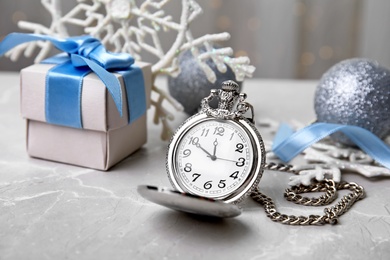 Photo of Pocket watch, gift and festive decor on table. Christmas countdown