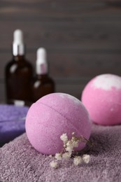 Beautiful aromatic bath bomb and gypsophila flowers on soft towel, closeup. Space for text