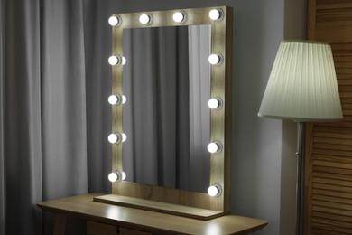 Beautiful mirror with light bulbs and lamp in makeup room