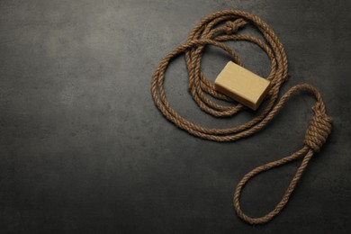 Photo of Rope noose and soap bar on grey table, flat lay. Space for text