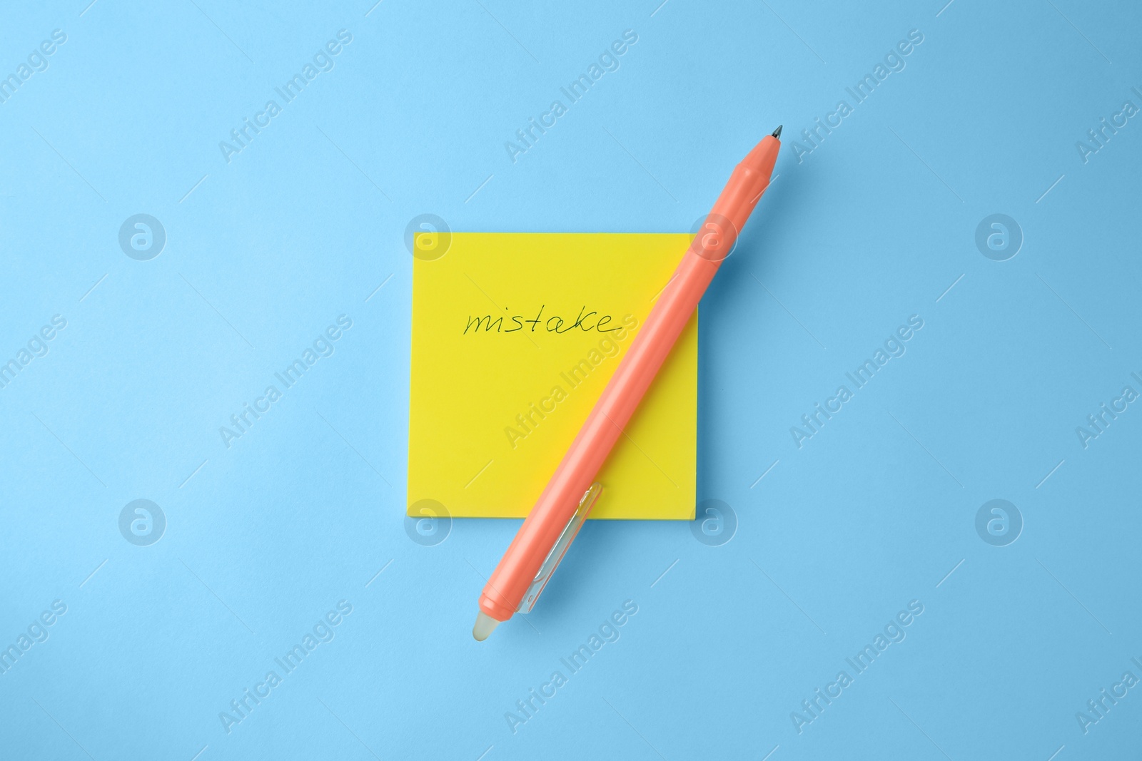Photo of Paper notes with word Mistake and erasable pen on light blue background, top view