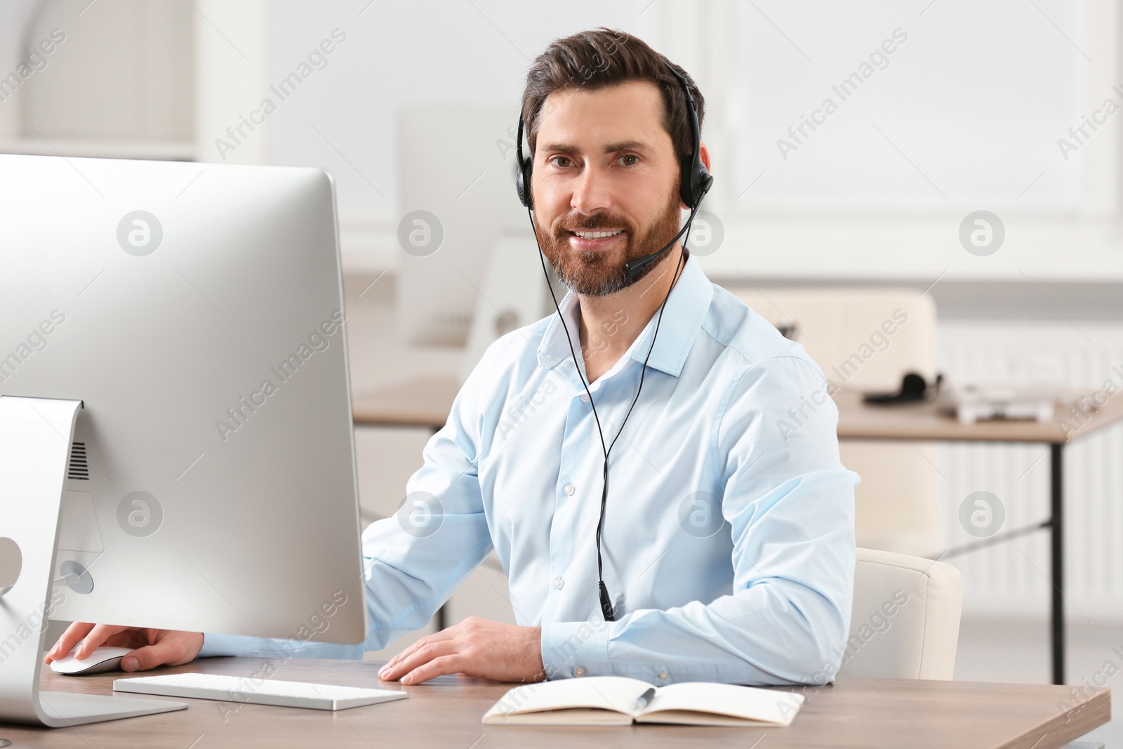 Photo of Hotline operator with headset working in office