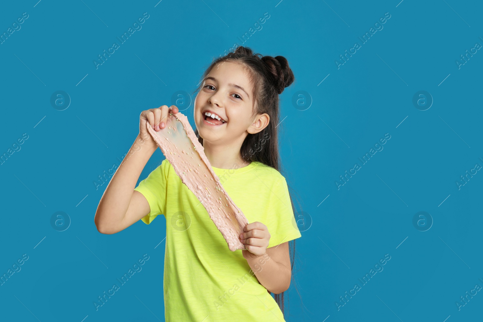 Photo of Little girl with slime on blue background