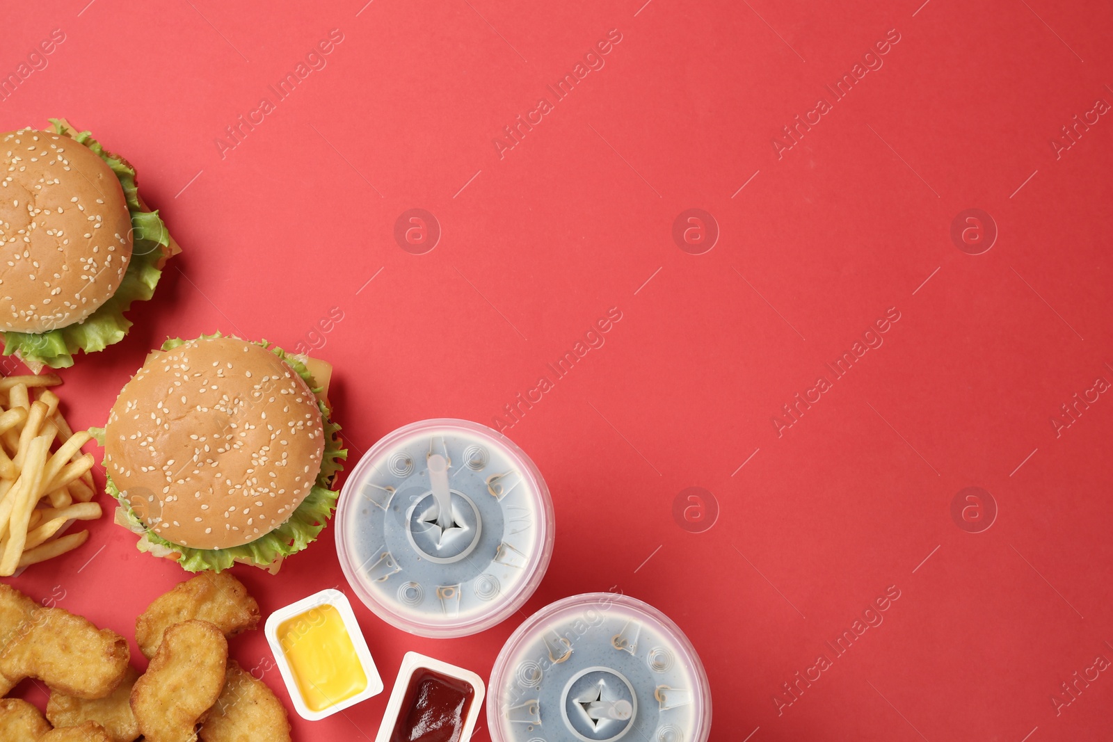 Photo of Flat lay composition with delicious fast food menu on red background. Space for text