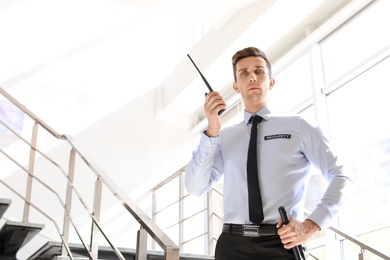 Photo of Male security guard with portable radio transmitter indoors