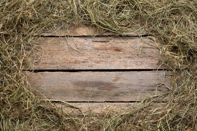 Frame made of dried hay on wooden table, top view. Space for text