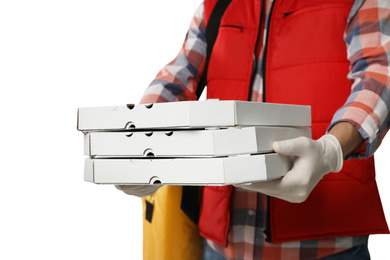 Photo of Courier in protective gloves holding pizza boxes on light background, closeup. Food delivery service during coronavirus quarantine