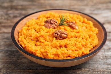 Photo of Bowl with mashed sweet potatoes on wooden table