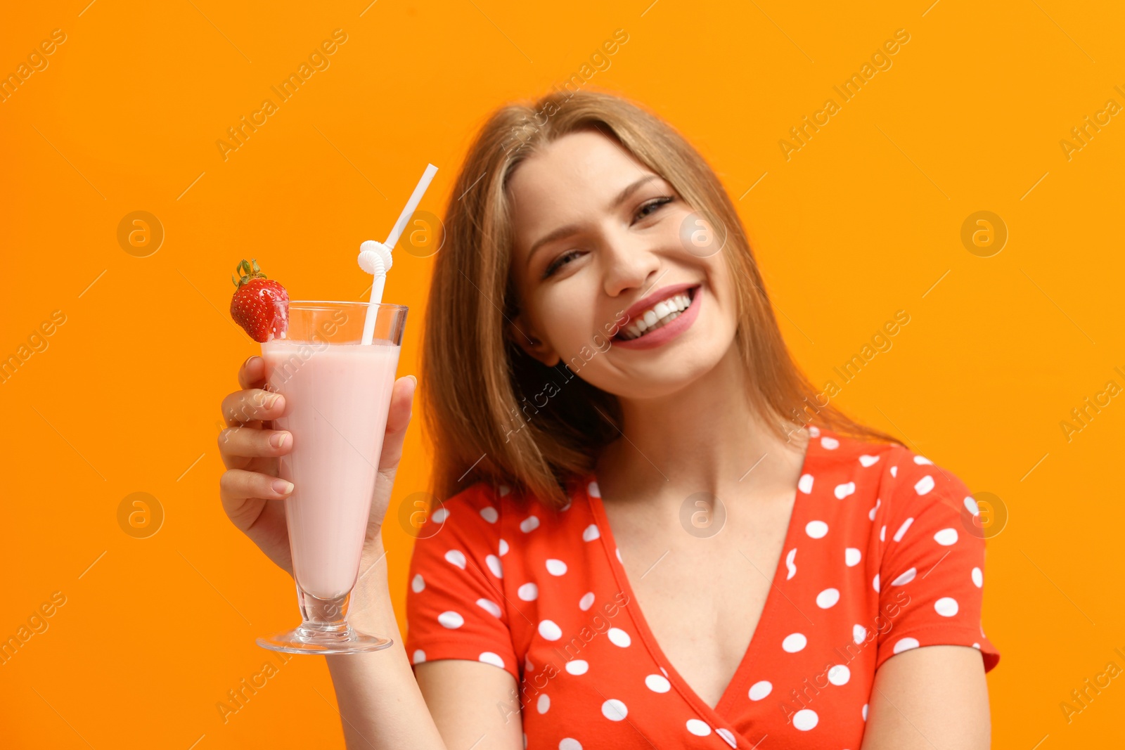 Photo of Young woman with glass of delicious milk shake on color background