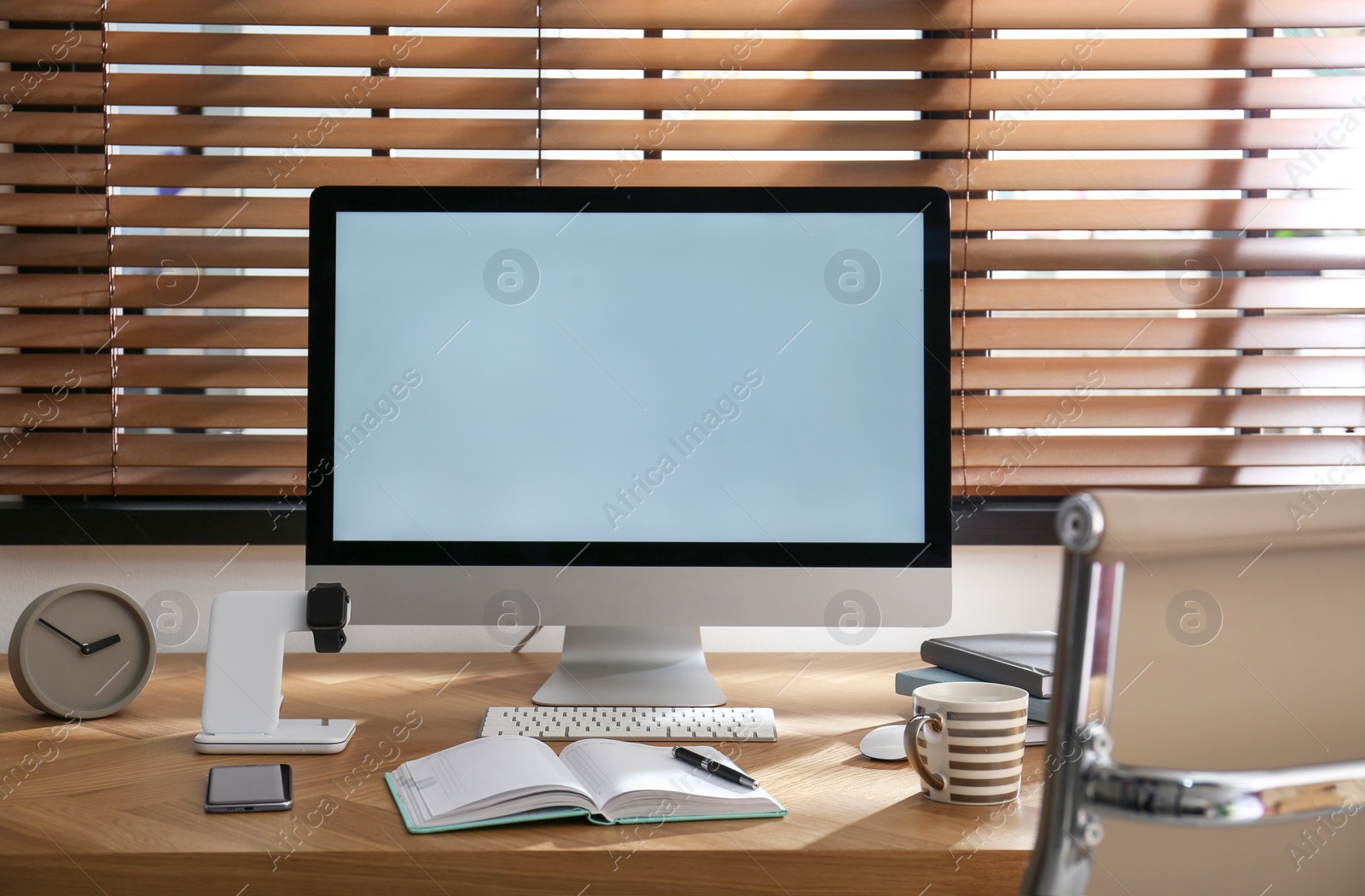 Photo of Modern workplace and watch charging with wireless pad