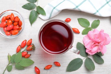 Flat lay composition with aromatic rose hip tea on white wooden table