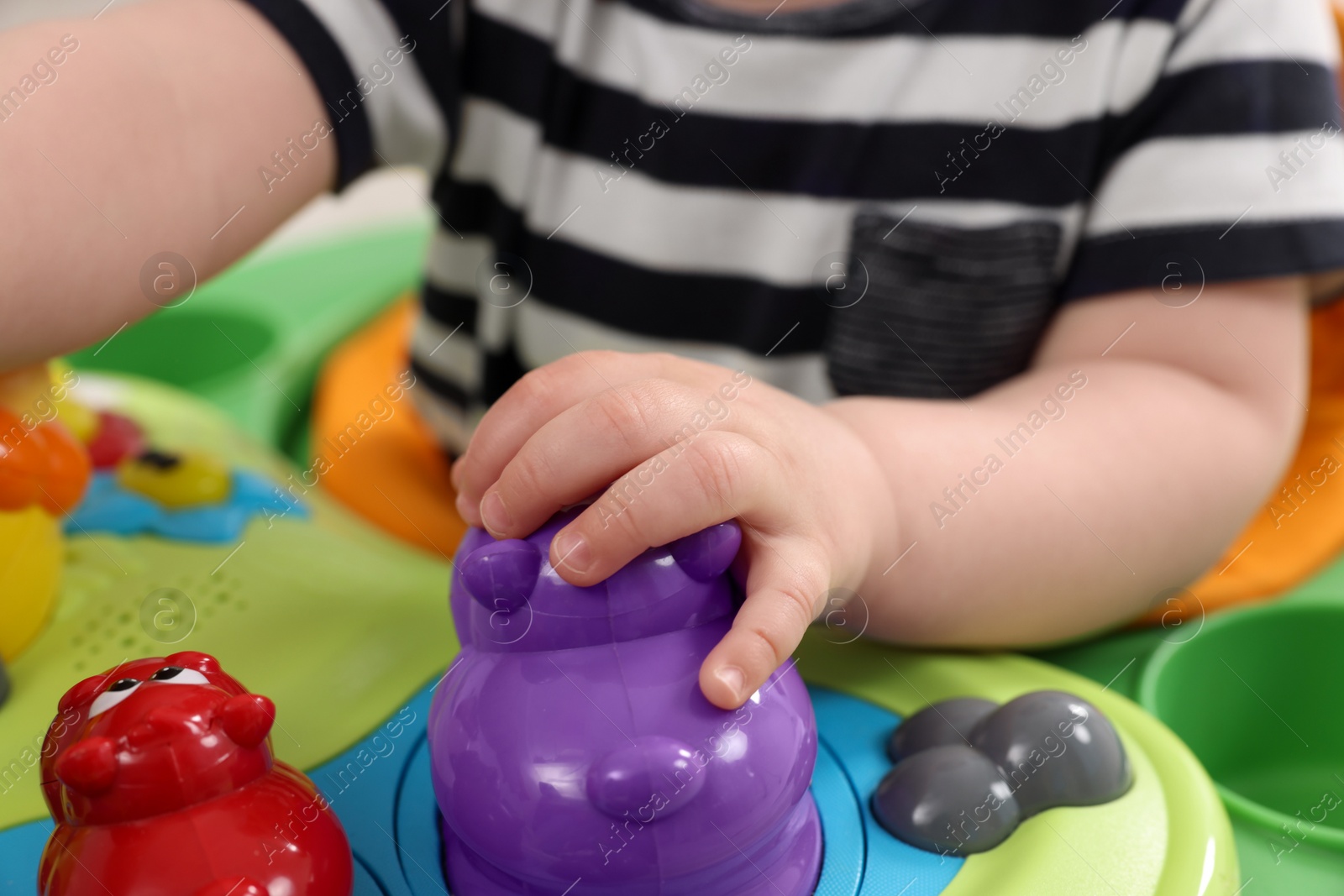 Photo of Little baby playing with toy walker, closeup