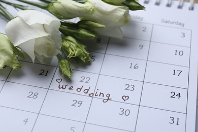 Photo of Calendar with date reminder about Wedding Day and flowers, closeup