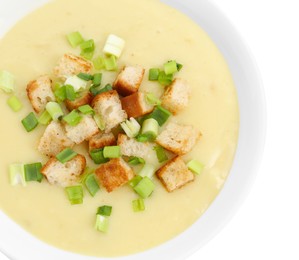 Photo of Tasty potato soup with croutons and green onion in bowl isolated on white, top view