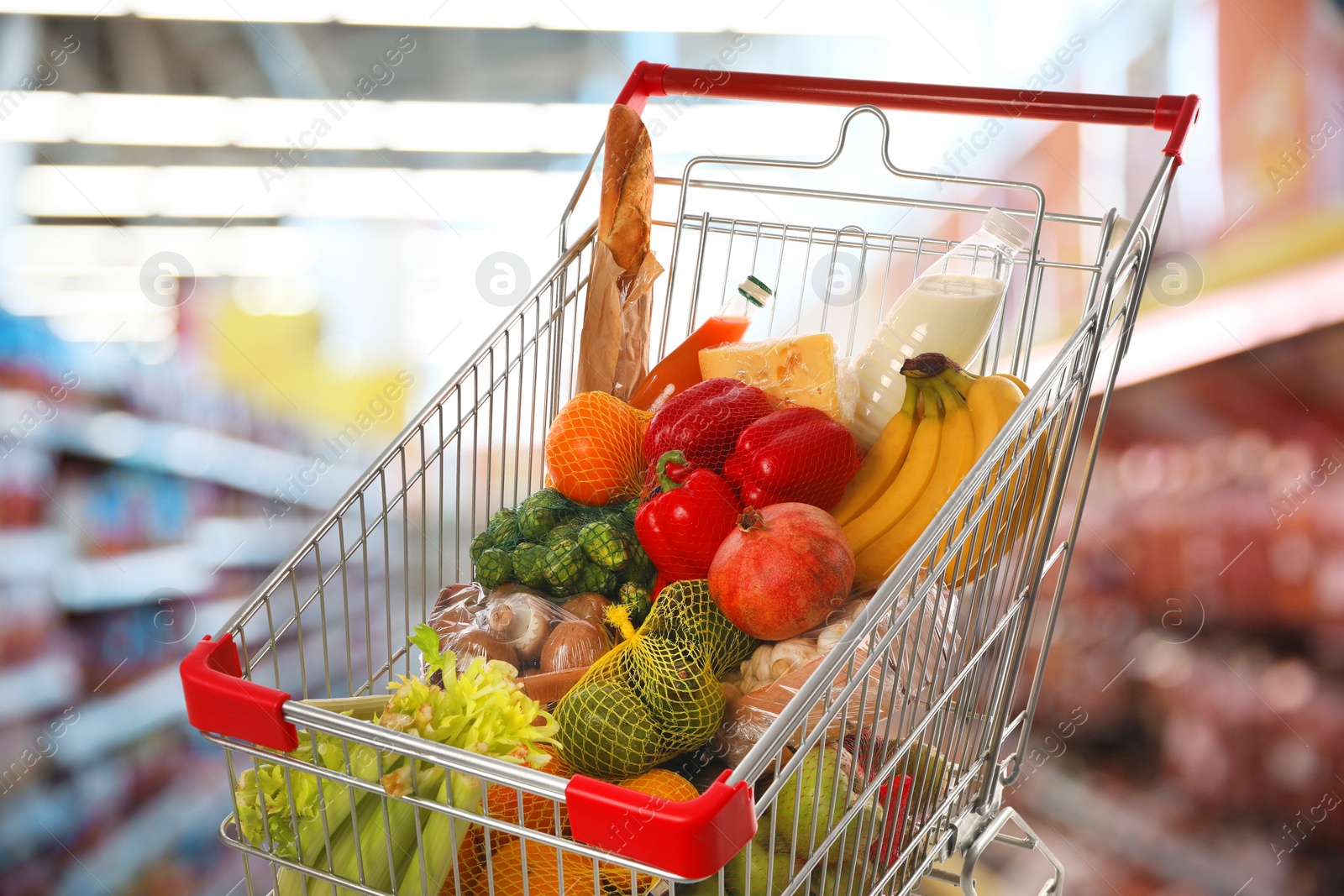 Image of Shopping cart with different groceries in supermarket