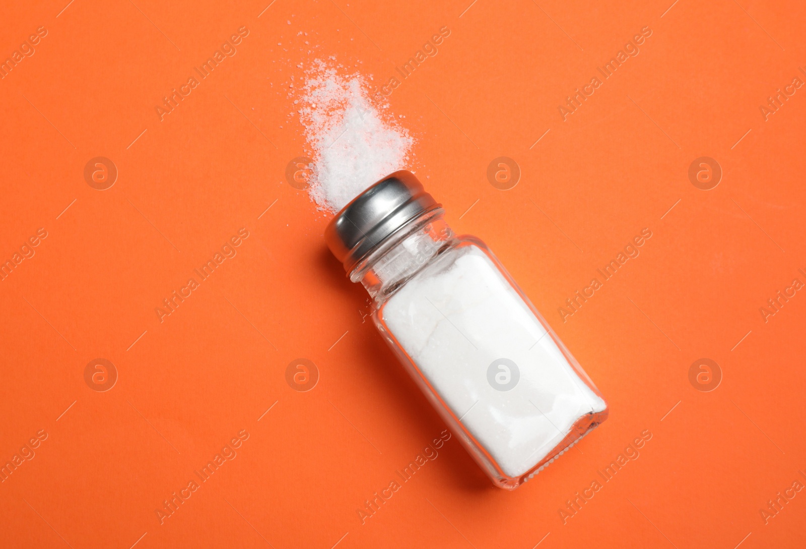 Photo of Salt shaker on orange table, top view