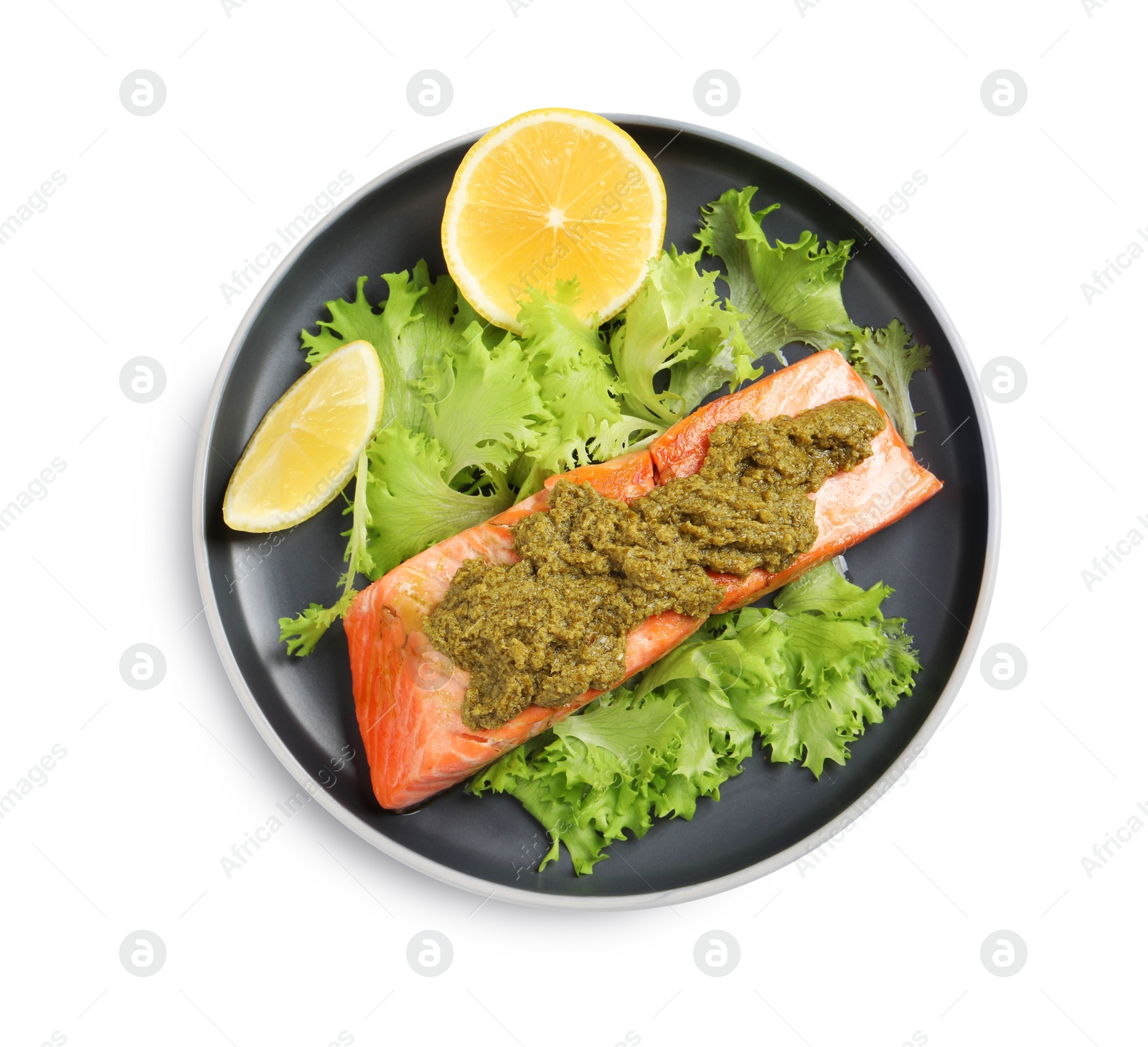 Photo of Delicious cooked salmon with pesto sauce, lettuce and lemon on white background, top view