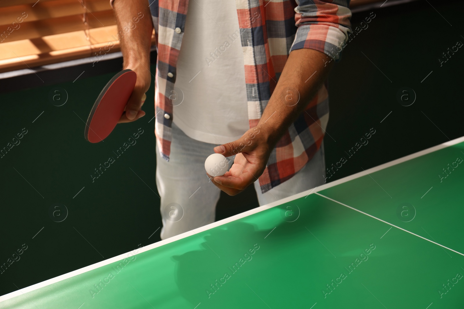 Photo of Man playing ping pong indoors, closeup view